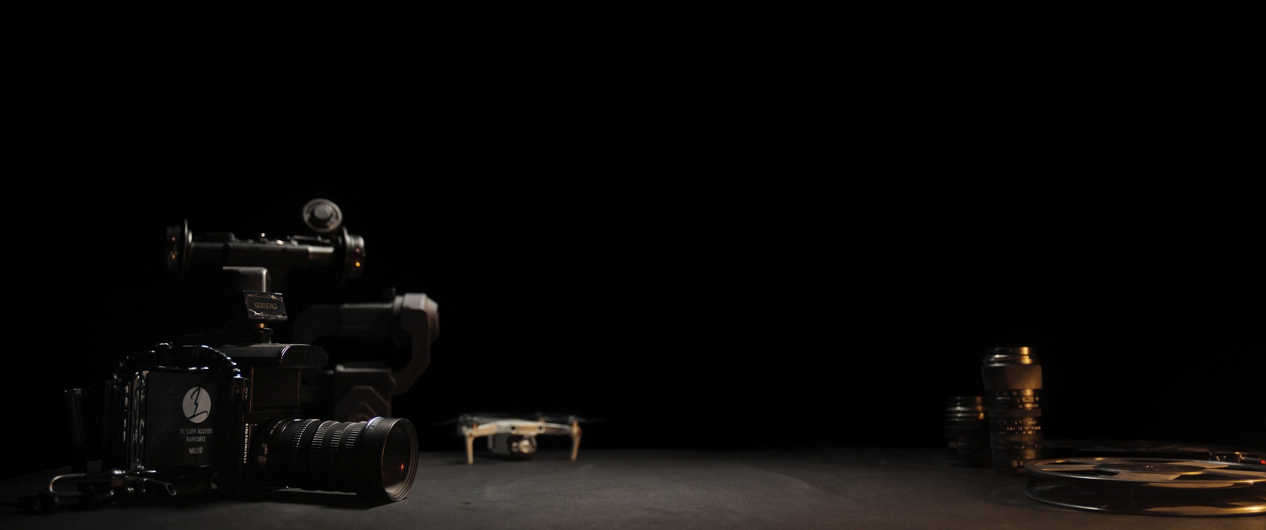 Professional cinema camera, lenses, gimbal and drone arranged in a dark, black and gold cinematic still life — the equipment behind every MR Productions film